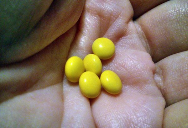 Желтые таблетки в руке